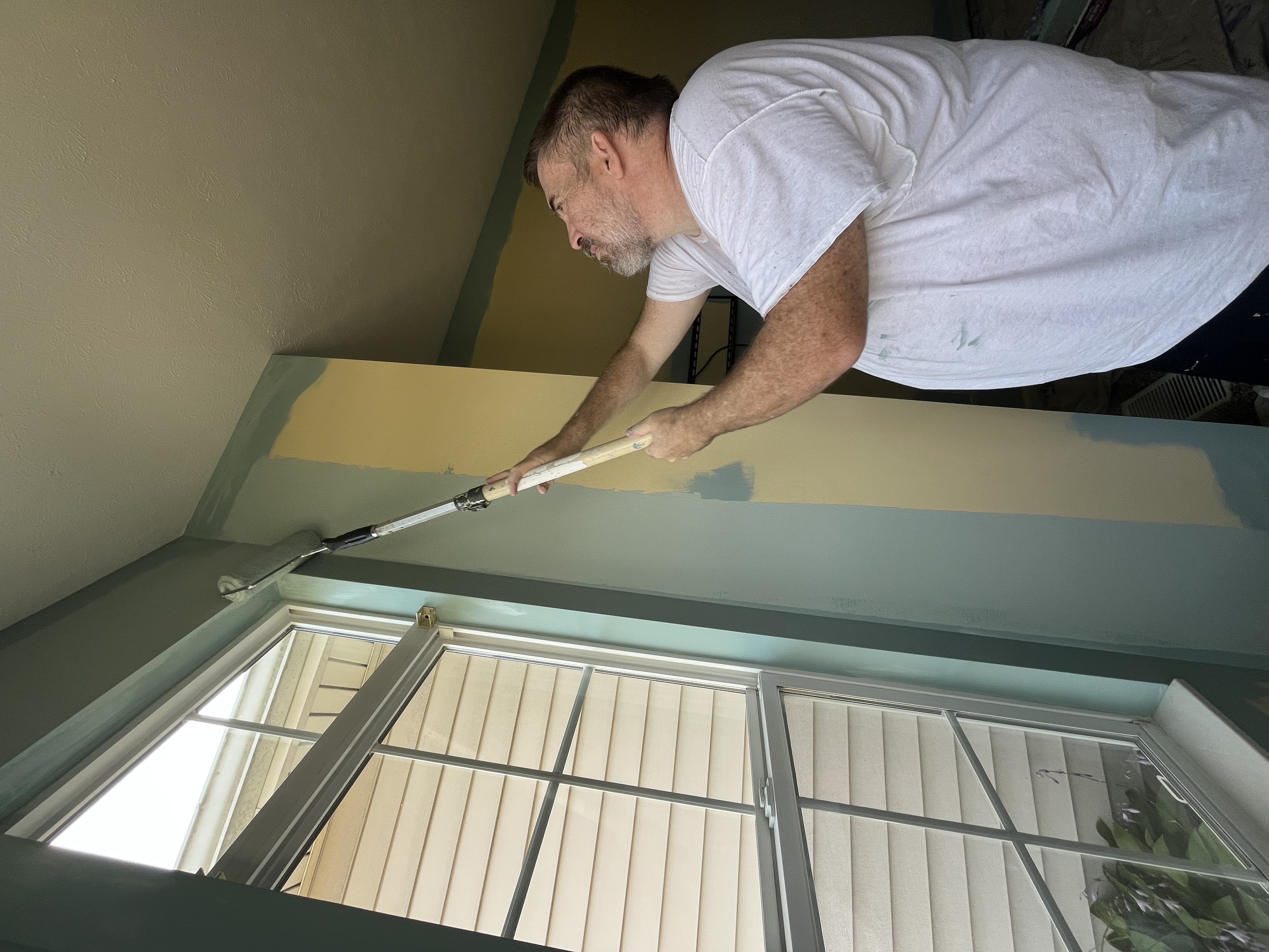 Painter rolling ceiling on interior painting job